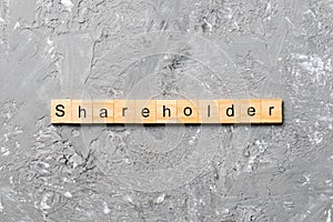 Shareholder word written on wood block. shareholder text on table, concept