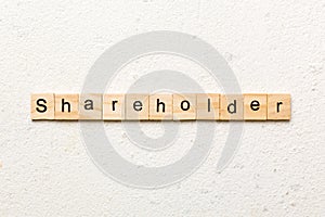 shareholder word written on wood block. shareholder text on table, concept