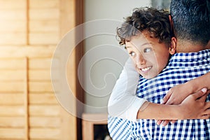 He shares a very special bond with his Dad. a little boy hugging his father at home.