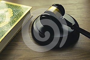 Sharia or Islamic law concept with gavel and Quran on wooden background