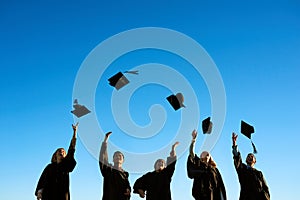 Sharing in the celebrations of a glorious day. a group of students throwing their hats in the air on graduation day.