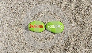 Sharing economy symbol. Concept words Sharing economy on beautiful green stone. Beautiful sand beach background. Business sharing