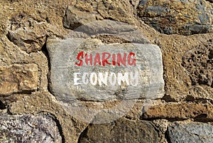 Sharing economy symbol. Concept words Sharing economy on beautiful grey stone. Beautiful brown stone wall background. Business