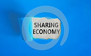 Sharing economy symbol. Concept words Sharing economy on beautiful white paper. Beautiful blue paper background. Business sharing