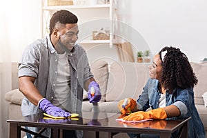 Sharing Household Chores. Black Young Spouses Spring-Cleaning Flat Together, Wiping Dust photo