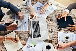 Sharing ideas while enjoying some coffee. High angle shot of a group of unrecognizable businesspeople having a meeting