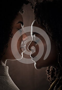 Sharing an intimate moment. a beautiful young female couple posing in studio against a dark background.