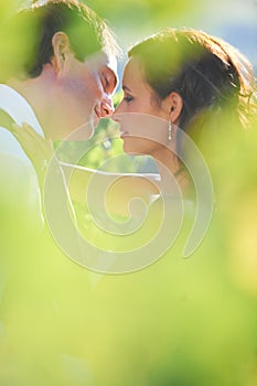 Sharing an intimate moment. A bride and groom kissing in a vineyard.