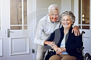 Sharing a life of love together. Portrait of a smiling senior woman in a wheelchair and her husband outside their home.