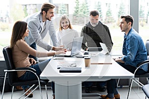 Sharing opinions. Group of young modern people in smart casual wear discussing business while working in the creative