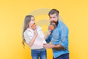 Sharing sweets with dearest people. Daughter and father eat sweet candies. Sweet dessert. Bearded hipster good daddy for photo