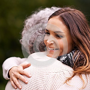 Sharing a warm embrace. a woman embracing her senior mother outside.