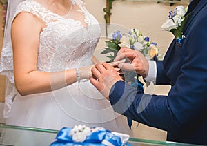 Sharing wedding rings. Groom puts ring on the bride`s finger