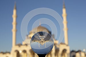 Sharjah Grand Mosque on lense ball, minaret of the largest mosque in Sharjah, United Arab Emirates.