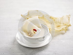 Shark Cartilage Soup with Fish Maw and Conpoy Served in a bowl isolated on wooden board side view on grey background