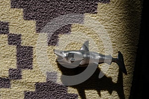 Shark toy on the carpet and its shadow