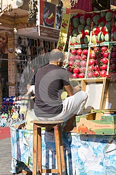 A typical shopping street with Arabic shops, the seller arranges the fruit on the street market, Sharm el Sheikh, Egypt