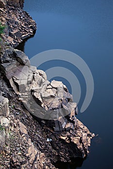 Sharp boulders bordering a dark blue lake