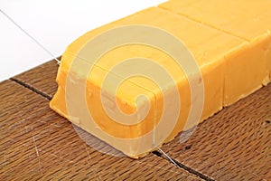 Sharp cheddar cheese being cut