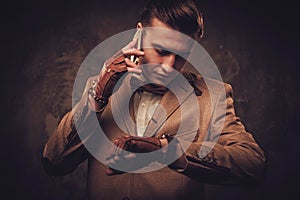 Sharp dressed man with mobile phone wearing jacket and bow tie