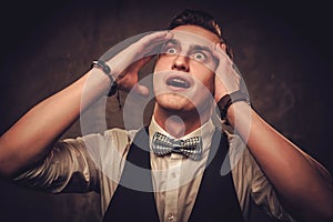 Sharp dressed man wearing bow tie showing emotions