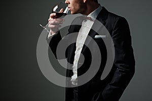 Sharp dressed man wearing jacket with glass of vine