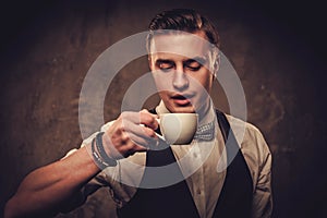 Sharp dressed man wearing waistcoat with a cup of coffee