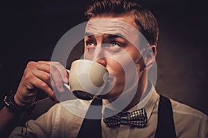 Sharp dressed man wearing waistcoat with a cup of coffee