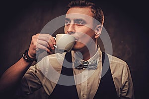 Sharp dressed man wearing waistcoat with a cup of coffee