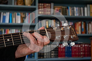 A Womans hand plays a C Chord on a classic Martin D28 guitar. Colorful image.