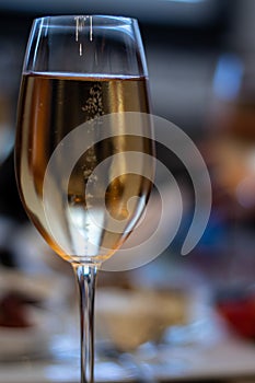 Sharp focus on single wine glass with white wine bubbling