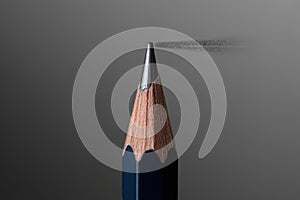 Sharp Graphite Pencil Tip with Dust Particles on a Smooth Gray Background Studio Shot