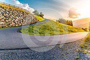 Sharp hairpin curve of narrow rural asphalt road in the mountains. Austrian Alps, Austria