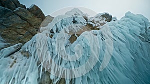 Sharp ice spikes dangling from rocks. Icicles over my head. Lake Baikal, Siberia, Russia.