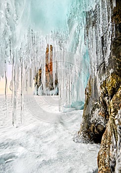 Sharp icicles hanging on coastal rock in early morning