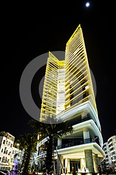 Sharp pointed wedge shaped hotel, night, illuminated levels unusual modern building