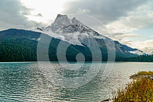 Sharp rocky mountain on the shore of Lake Minnewanka in the Canadian Rockies - vertical