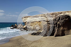 Sharp rugged cliff and rocks on isolated secluded beach at north-west coast of Fuerteventura, Canary Islands, Spain