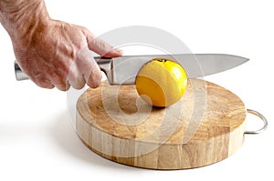 Sharp stainless steel knife cutting into orange