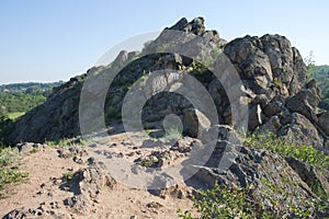 Sharp stones. Sharp rocks at the top of a hill in the Nikolaev region of Ukraine on a bright summer day. Cloudless blue sky over a