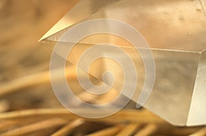 Sharp top point of faceted gem crystal quartz on natural background of needles closeup macrophotography