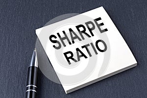 SHARPE RATIO text on the sticker with pen on the black background