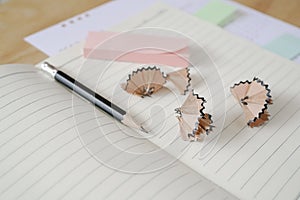 Sharpen pencil with blank line notebook on wooden desk