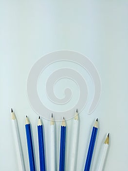Sharpen white and blue pencils on white background with copy space on top.