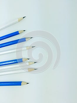 Sharpen white and blue pencils on white background with copy space on the right side.