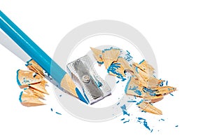 Sharpened blue pencil, silver metal sharpener, a lot of shavings from sharpening on isolated background