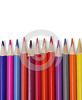 Sharpened colored wooden pencils on an white background, top view