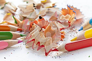 Sharpened colorful pencils and wood shavings, closeup