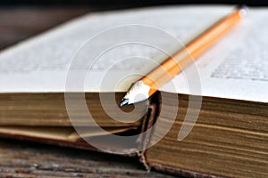 Sharpened Pencil and Old Book