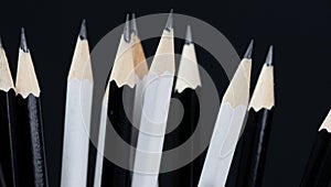 Sharpened tip of black and white pencils on black background